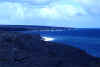 Lava flows into the ocean, plume of steam.